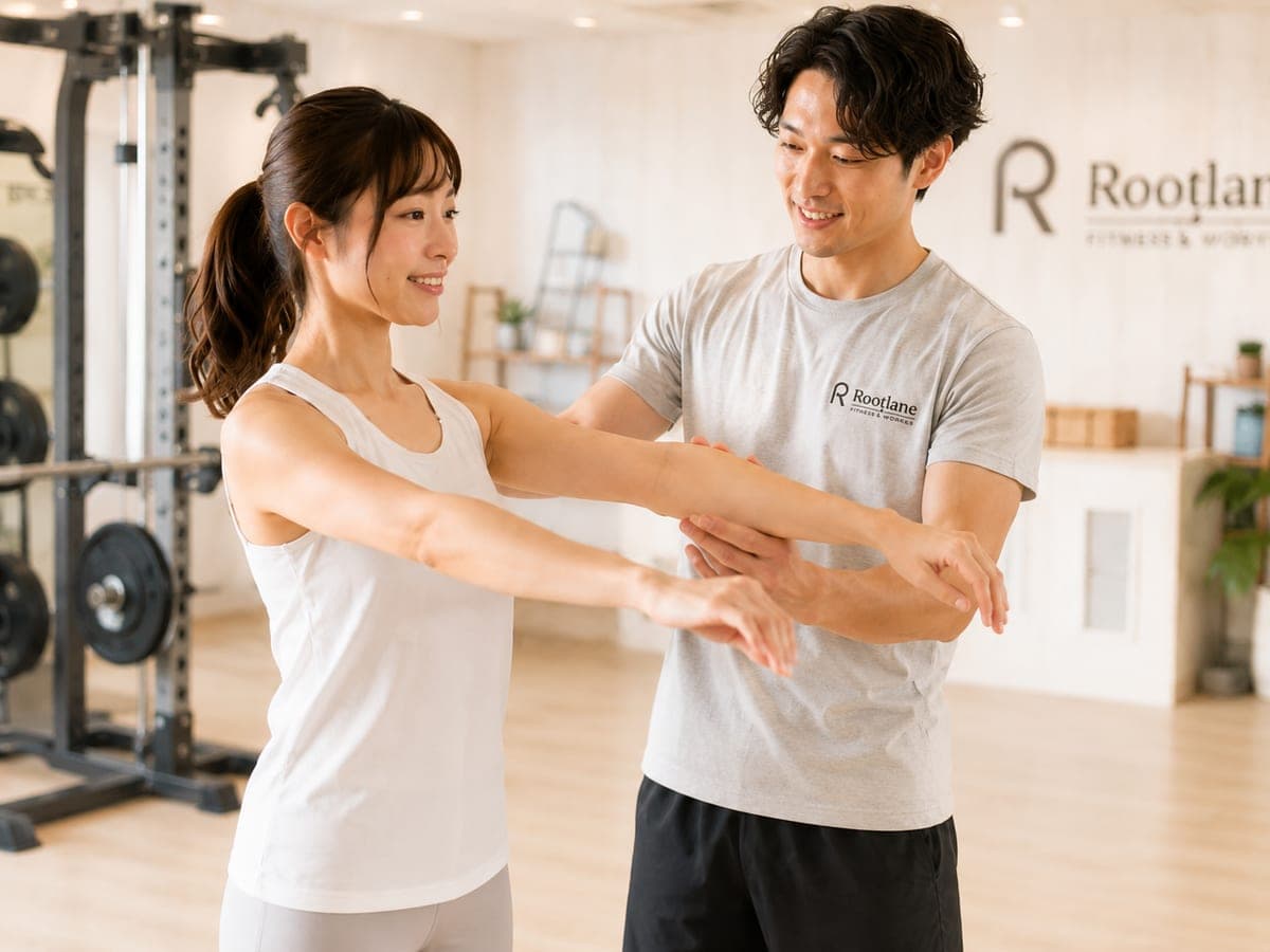 トレーナーが腕の位置と可動域を確認する様子