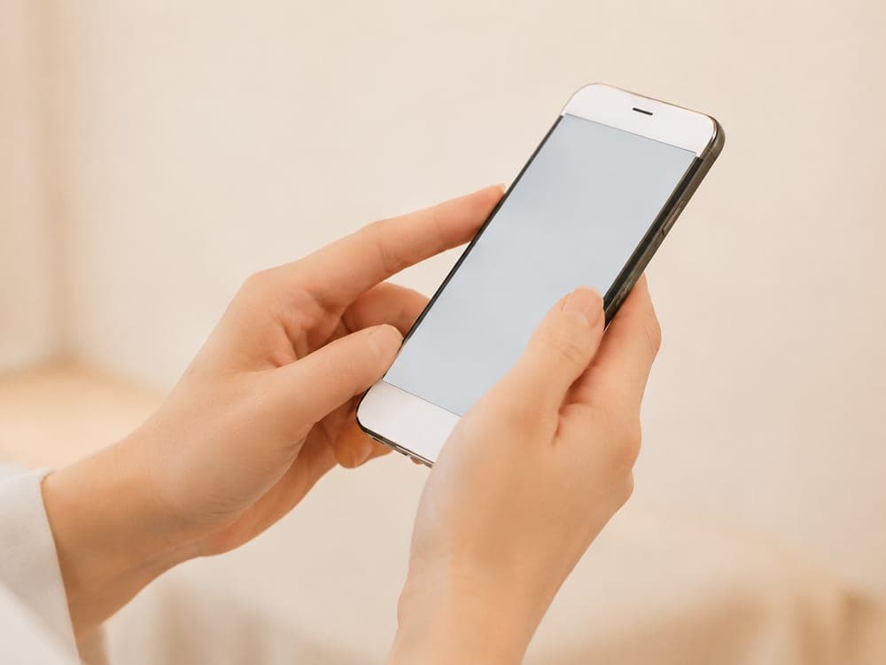 スマートフォンで体験予約フォームを操作する手元