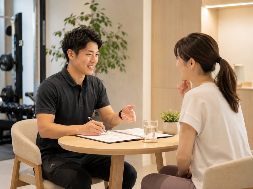 テーブルで通い方とプランの説明を受ける様子